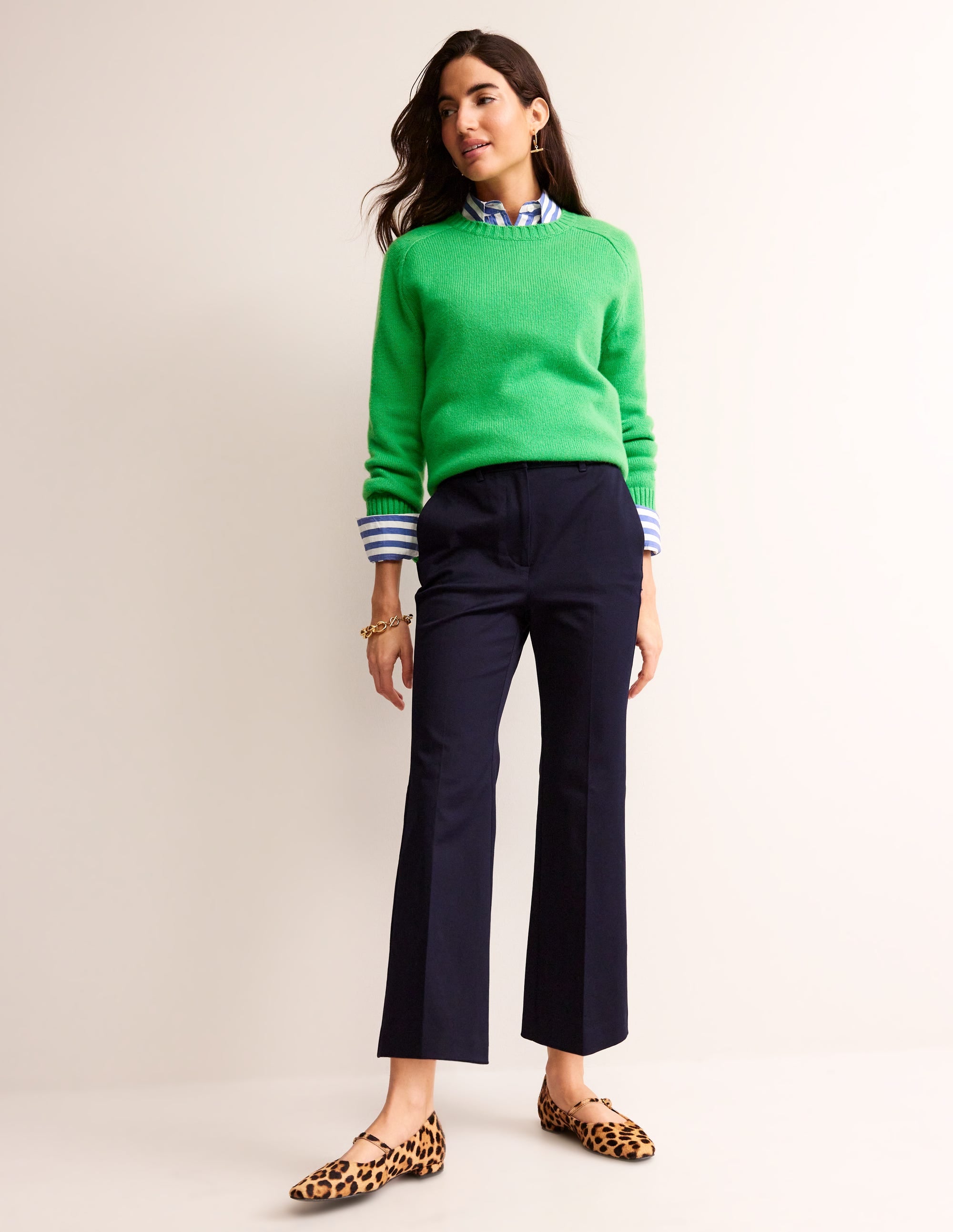 A pair of navy women's cropped trousers with a high waist, flared leg, and front and back pockets.