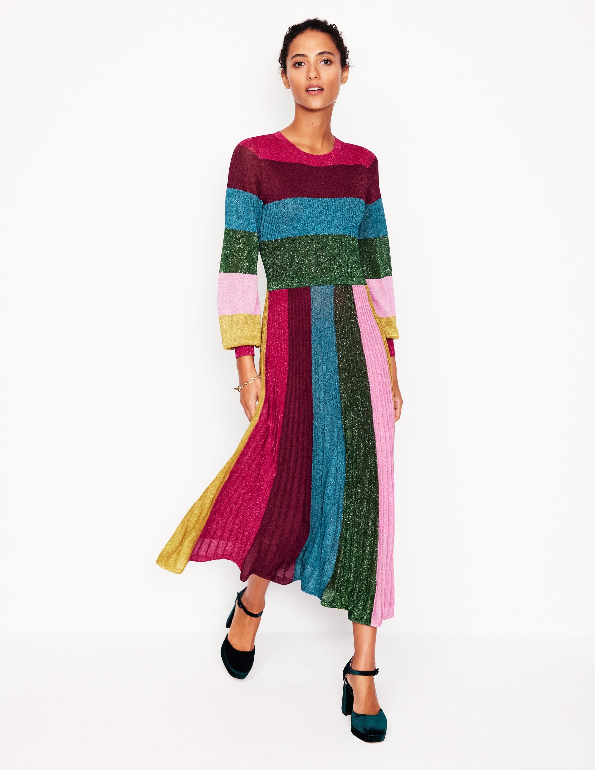 A woman wearing a multicoloured ribbed metallic panelled stripe midi dress with long sleeves and a fitted silhouette.