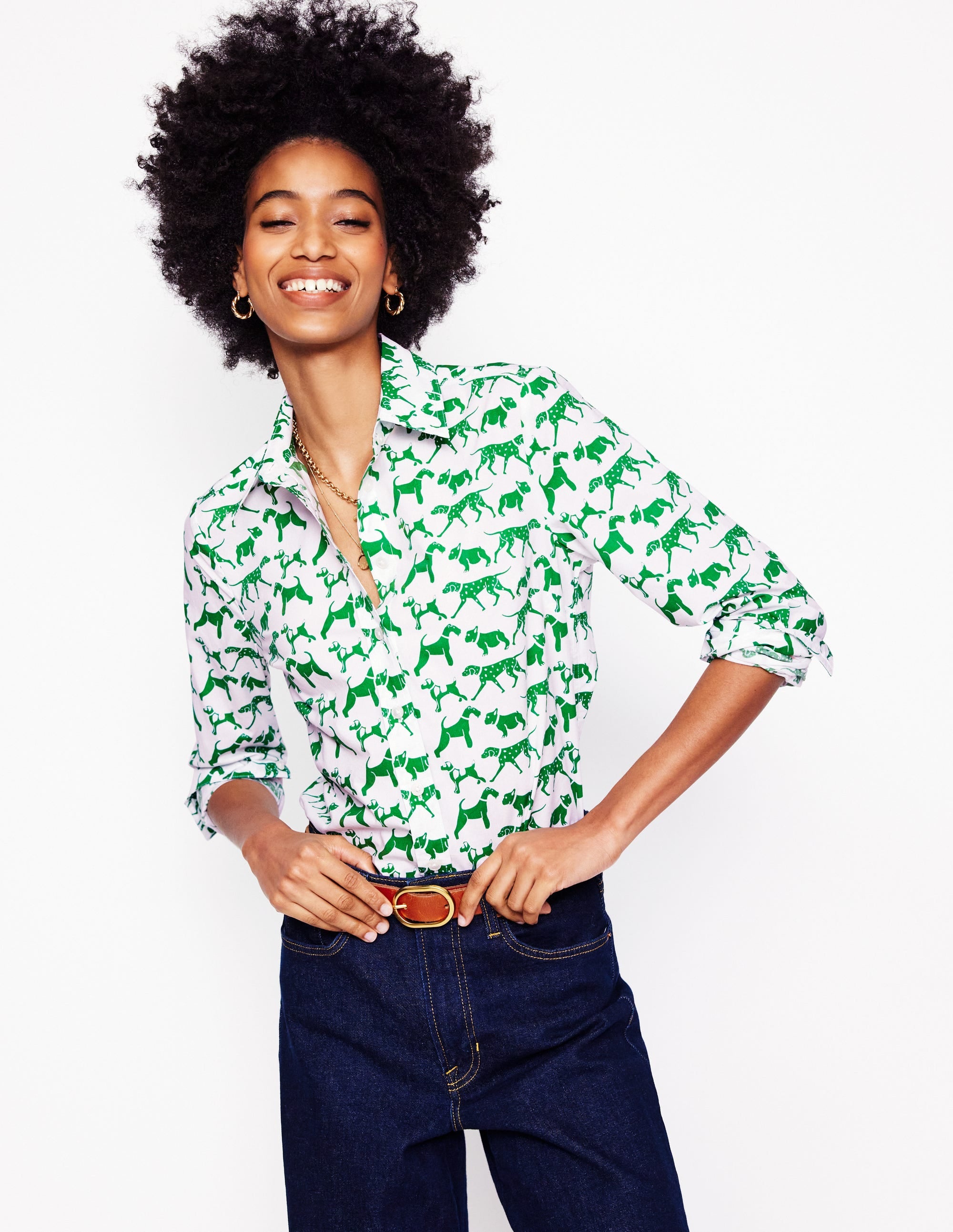 A woman wearing an ivory cotton shirt with a green animal print, long sleeves, and a classic collar.