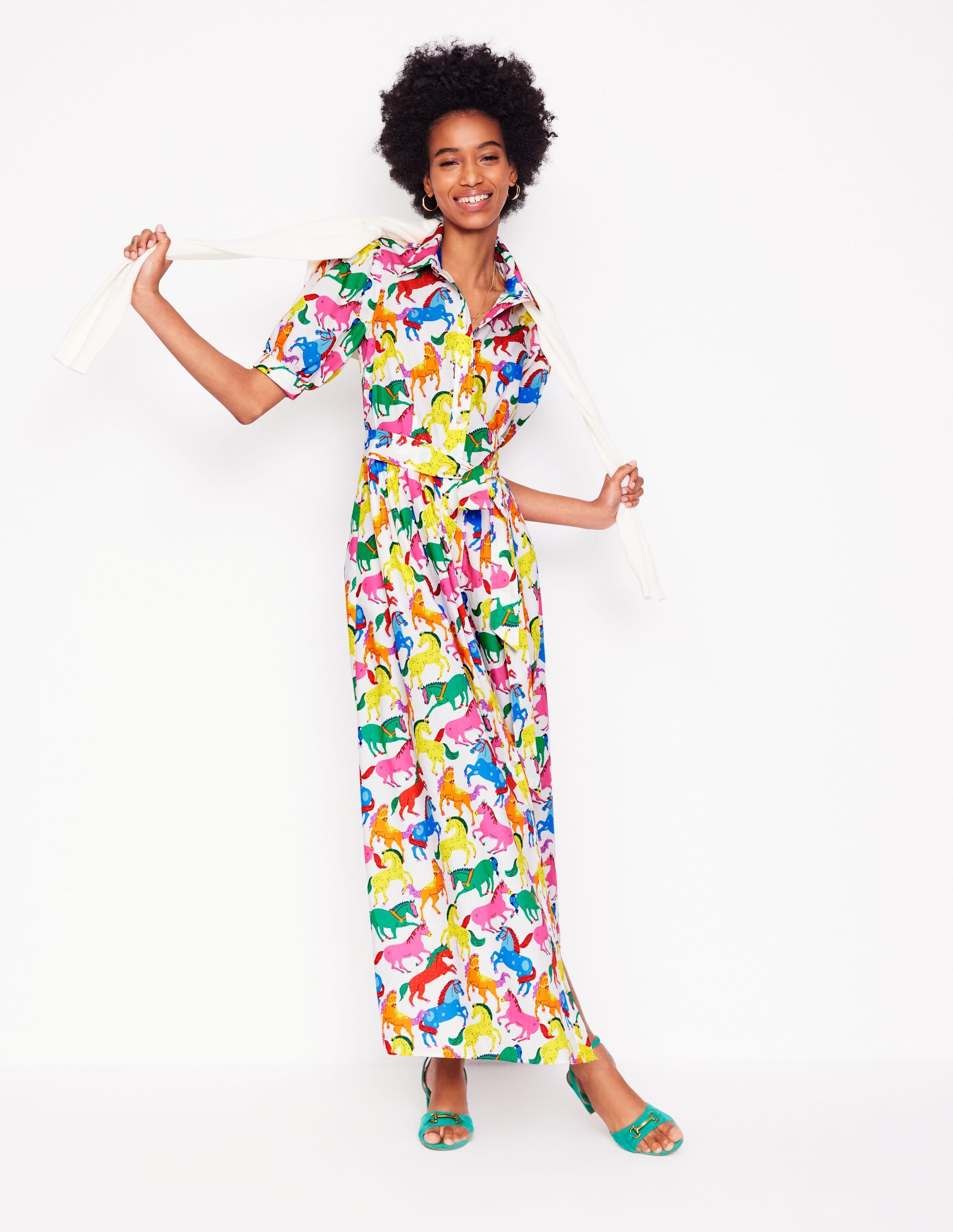 A woman wearing a vibrant, multicolored pony print maxi shirt dress with puff sleeves, a belt, and side pockets.