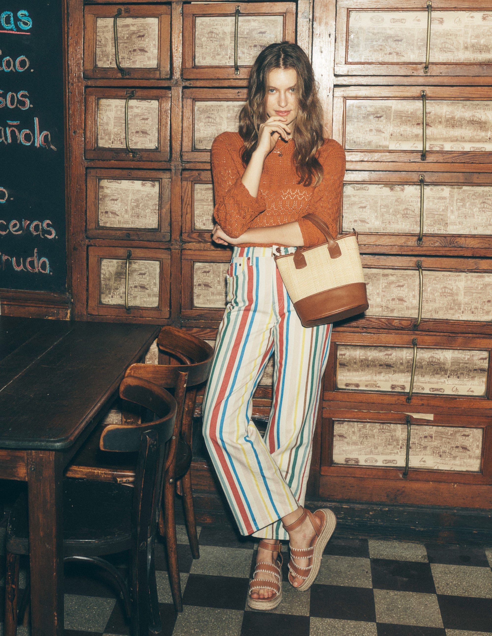 A pair of high-rise crop jeans with a green and pink rainbow stripe pattern, wide-leg cut, and stitch detailing at the hem.