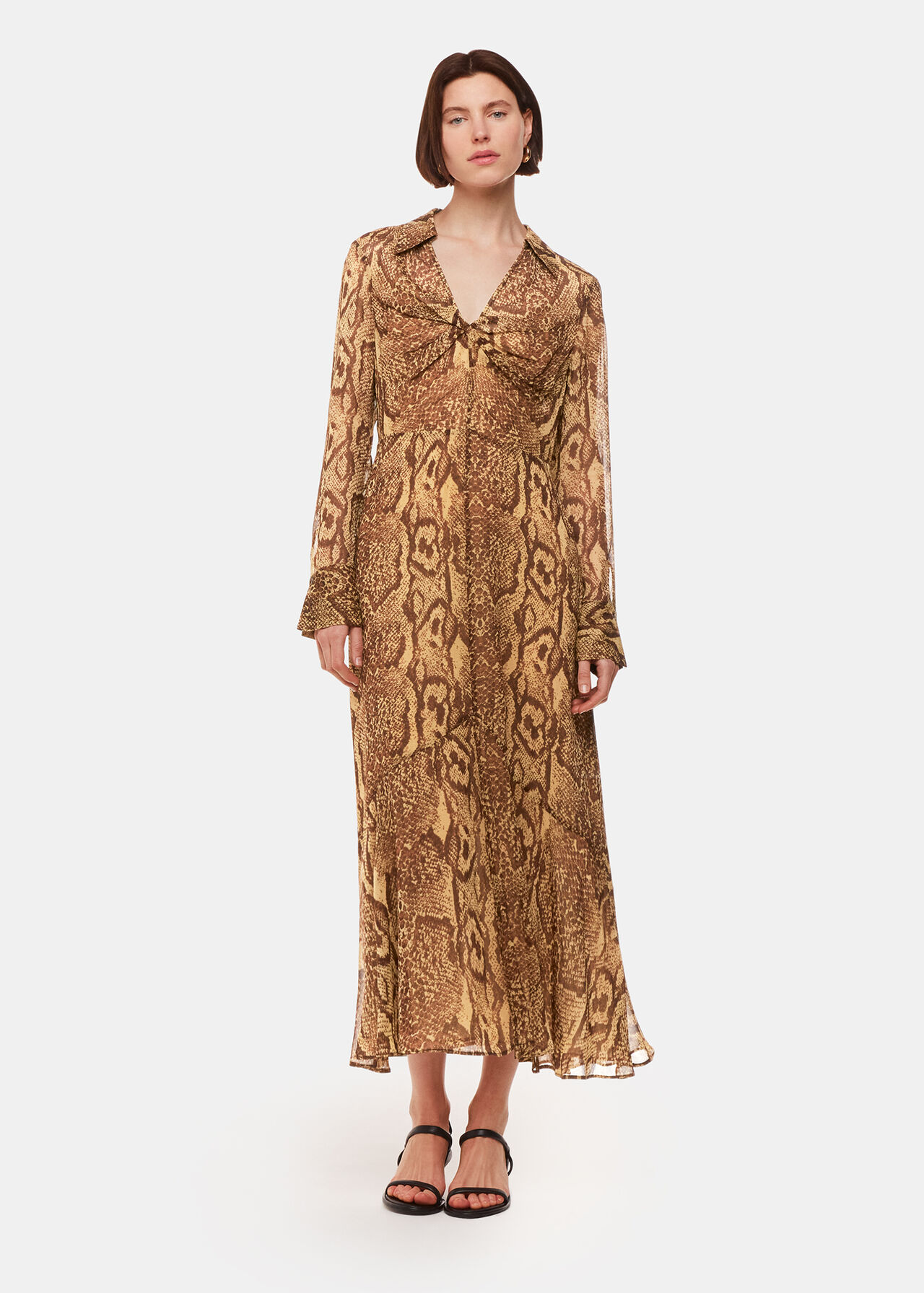 A woman wearing a long snake print midi dress with a collar and long sleeves, in shades of brown and beige.