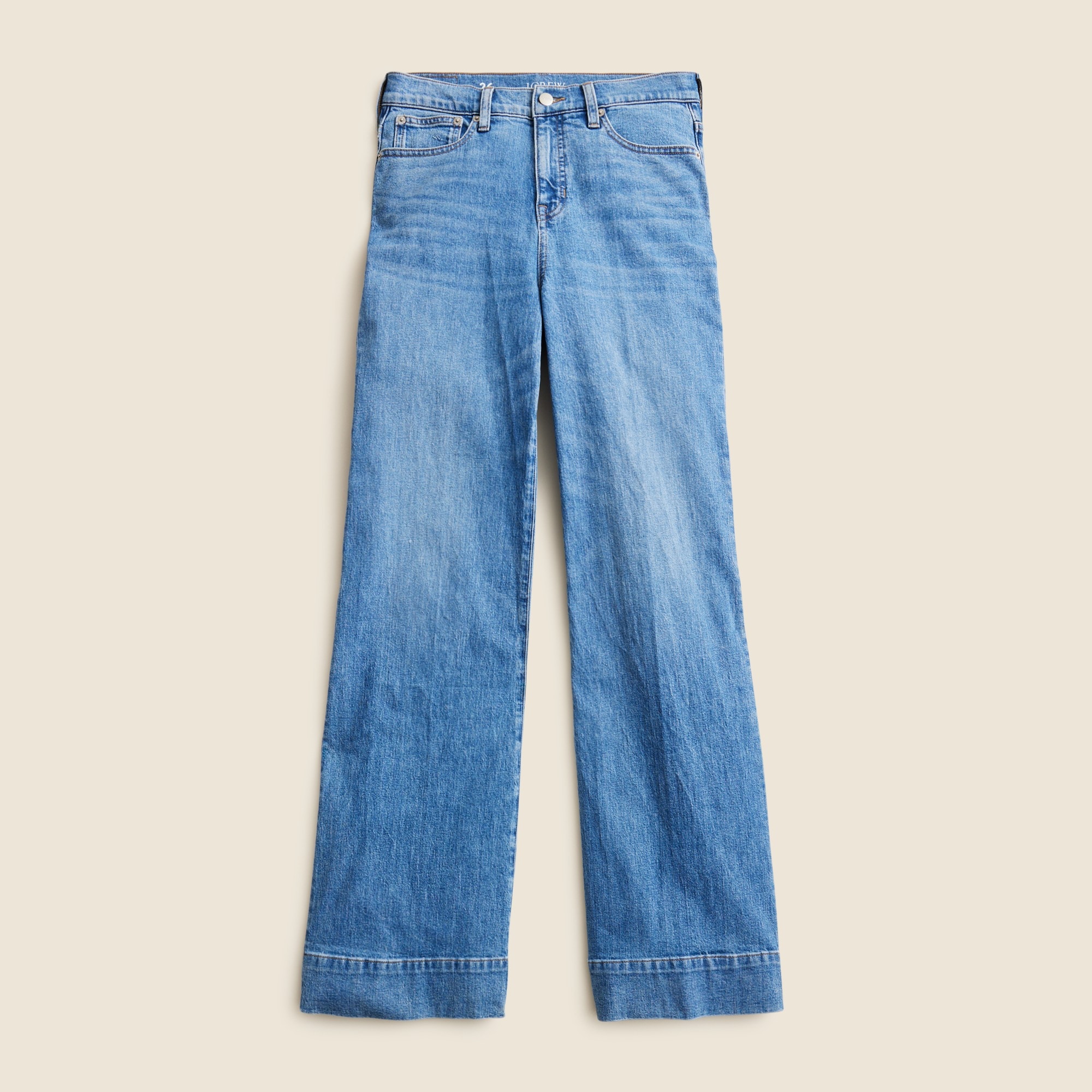 A pair of high-rise blue denim trousers with a wide-leg design, five pockets, and a zip fly.