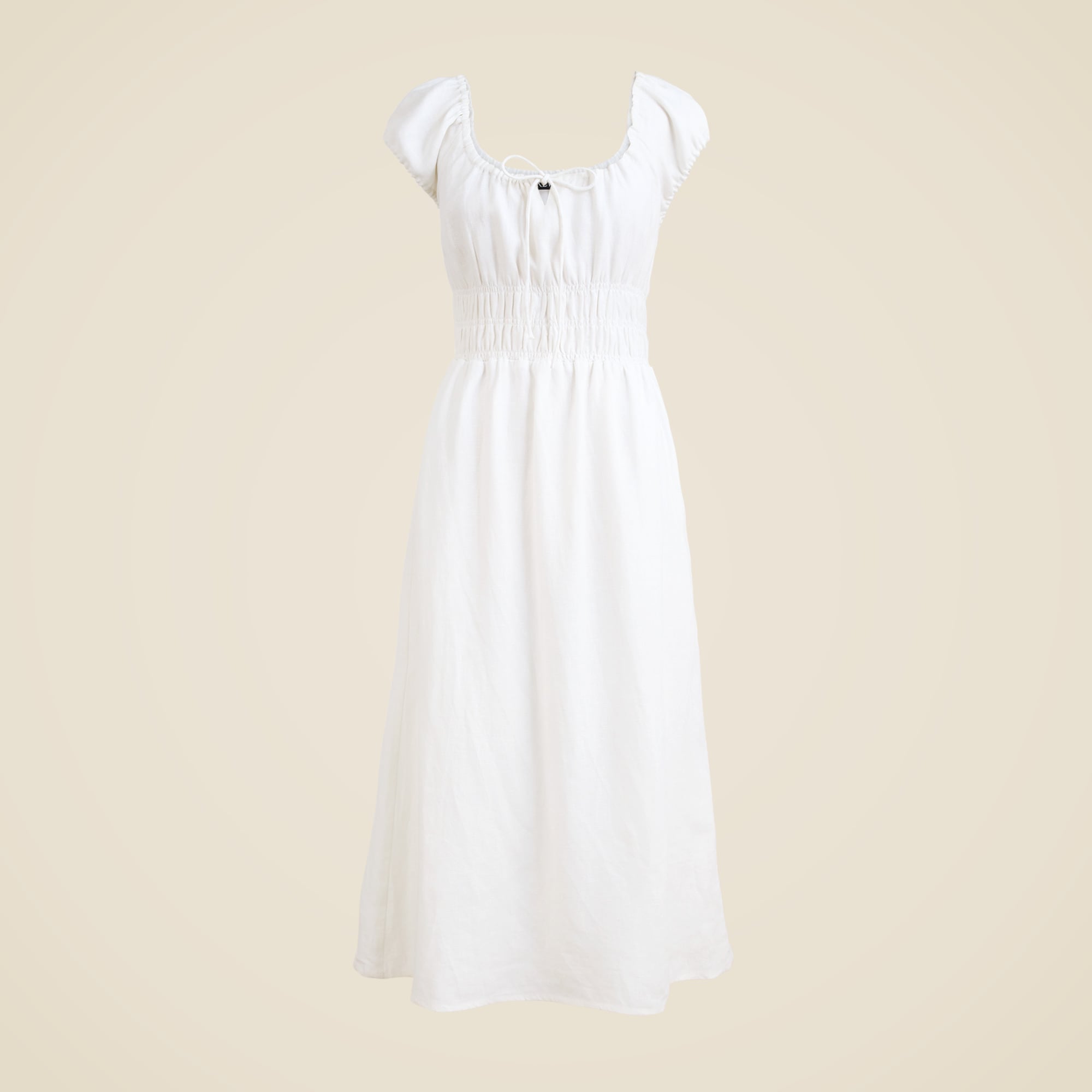 A white linen midi dress with cap sleeves, smocked waistband, and a tie at the center, displayed against a plain background.