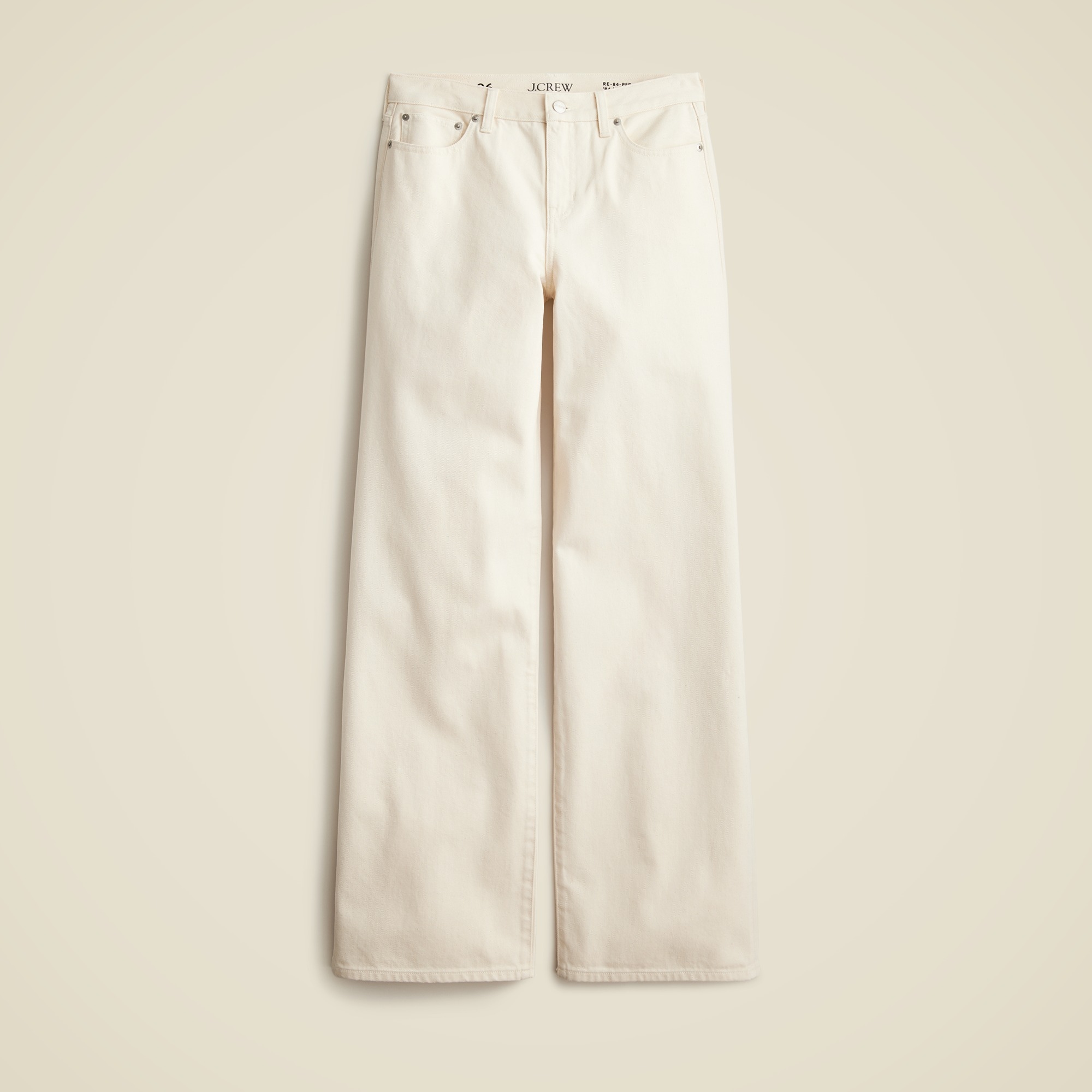 A pair of cream-colored, wide-leg jeans with a low-rise waist, five pockets, and a relaxed fit, laid flat against a neutral background.