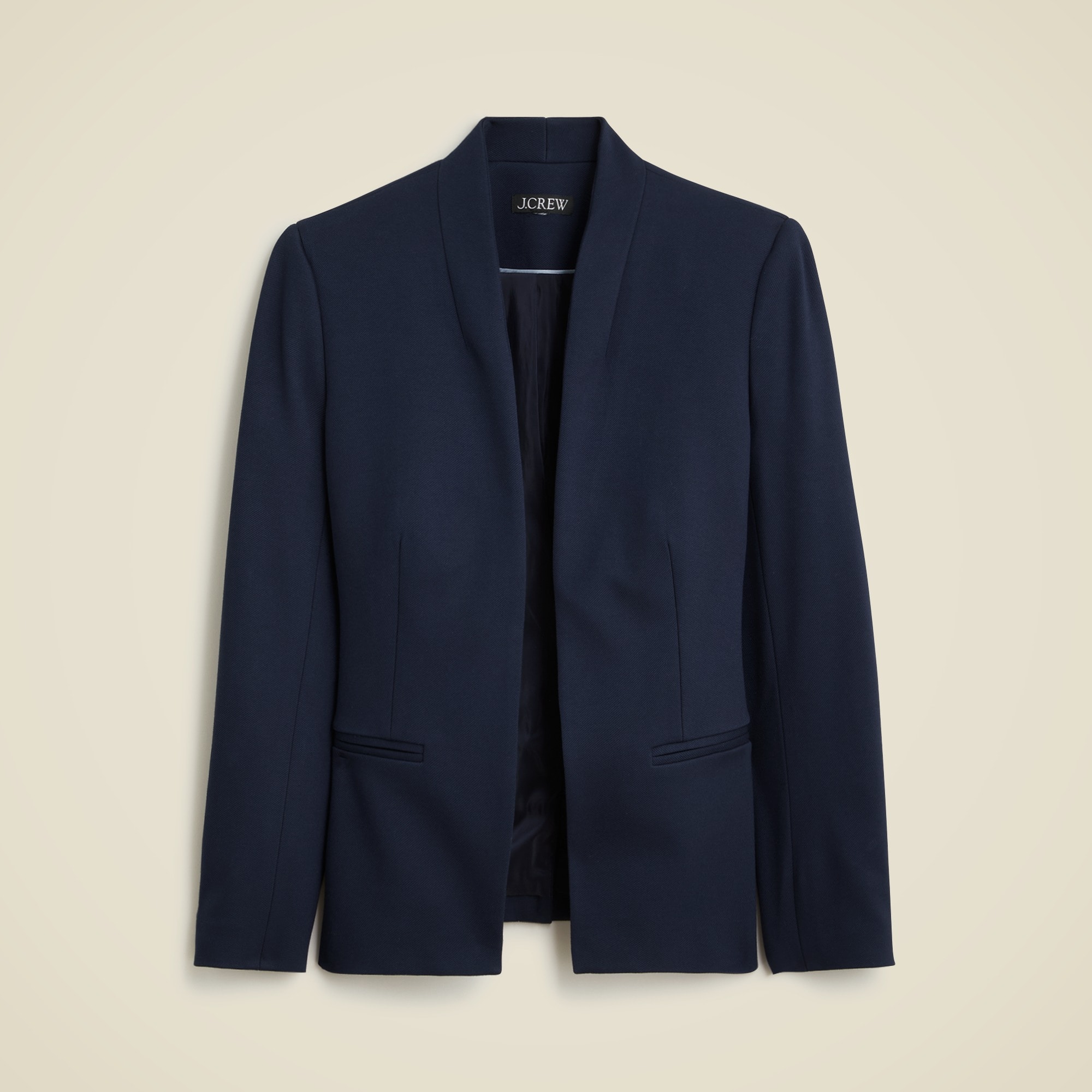 A women's navy blue blazer with a structured, slim fit design, open front, long sleeves, welt pockets, and a standing collar.