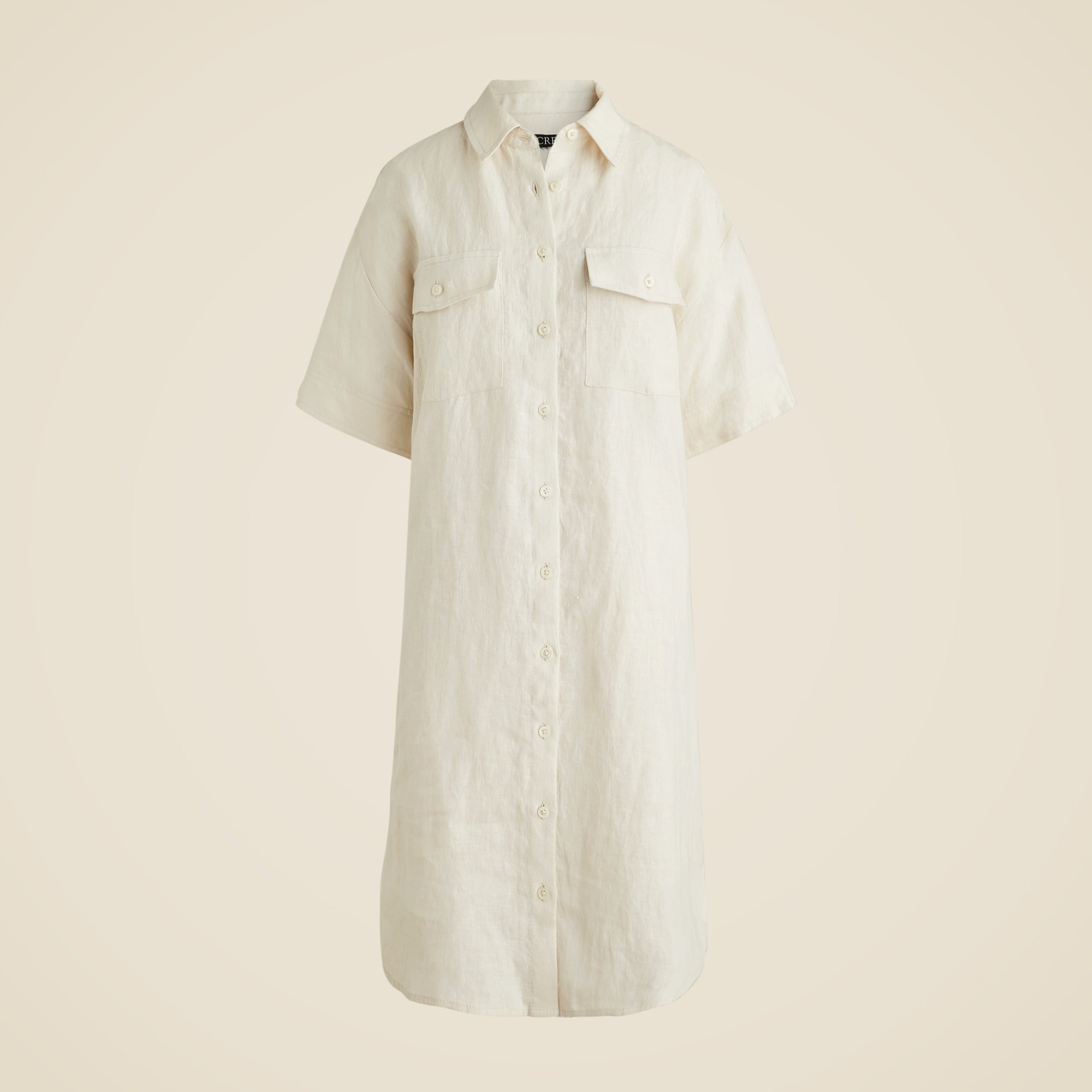 A women's beige linen utility shirtdress with short sleeves, button-front, and patch pockets.