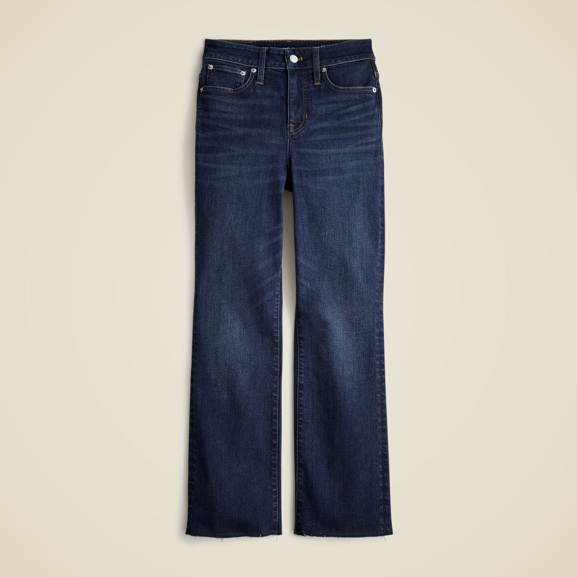 A pair of dark blue high-rise kickout jeans with a raw hem and five-pocket styling.