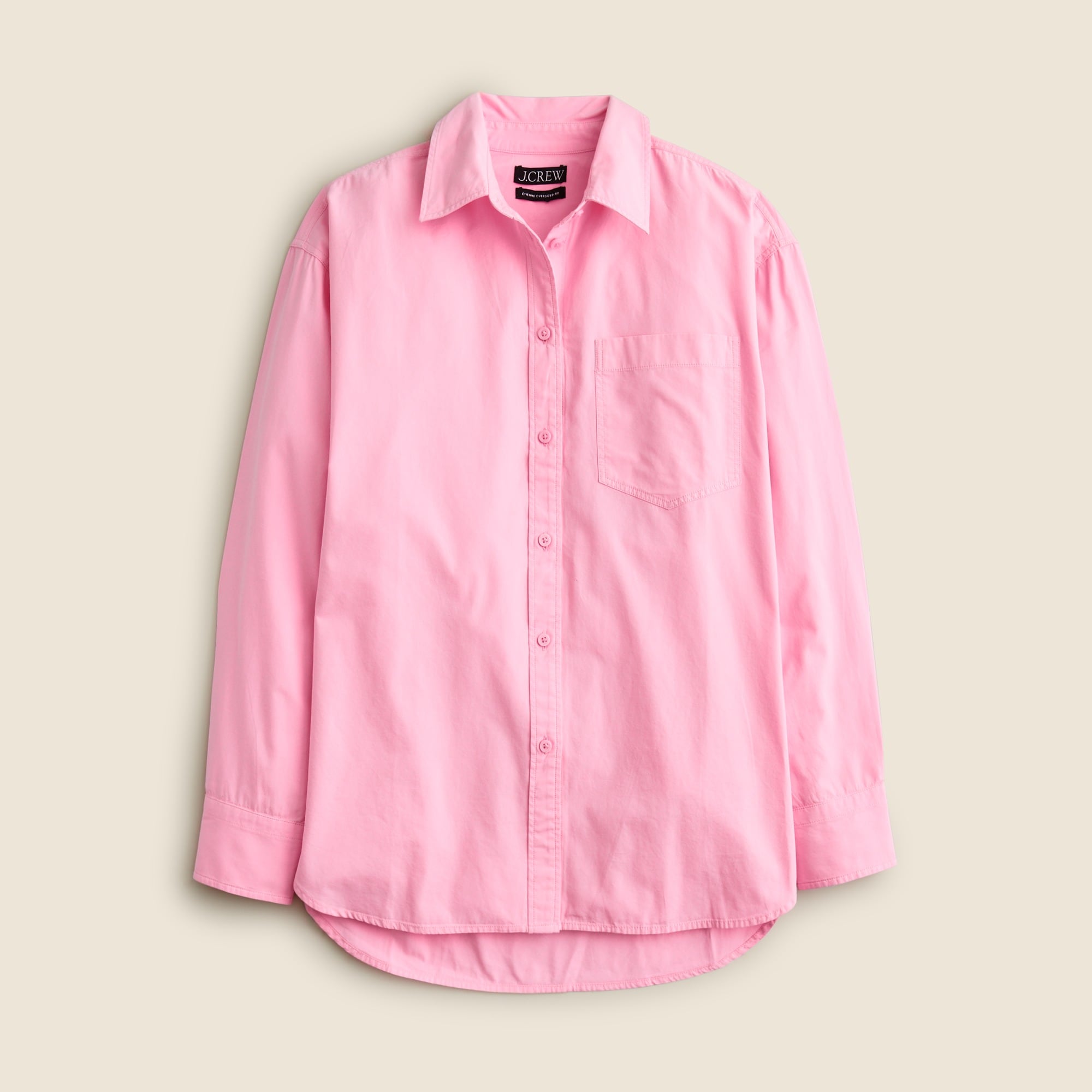 A pink oversized women's shirt with a collar, long sleeves, and a high-low hem, made from lightweight oxford fabric.