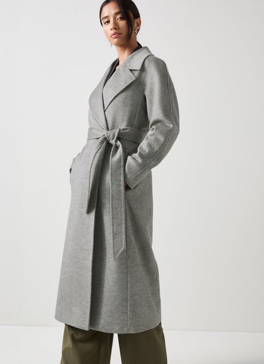 A woman wearing a long grey marl maxi coat with a collar, long sleeves, and a self-belt, standing against a plain background.