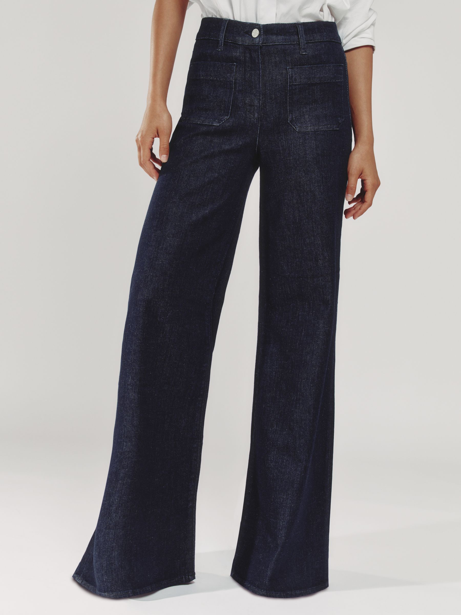A pair of dark blue wide-leg jeans with a high waist, front patch pockets, and a button and zip closure.