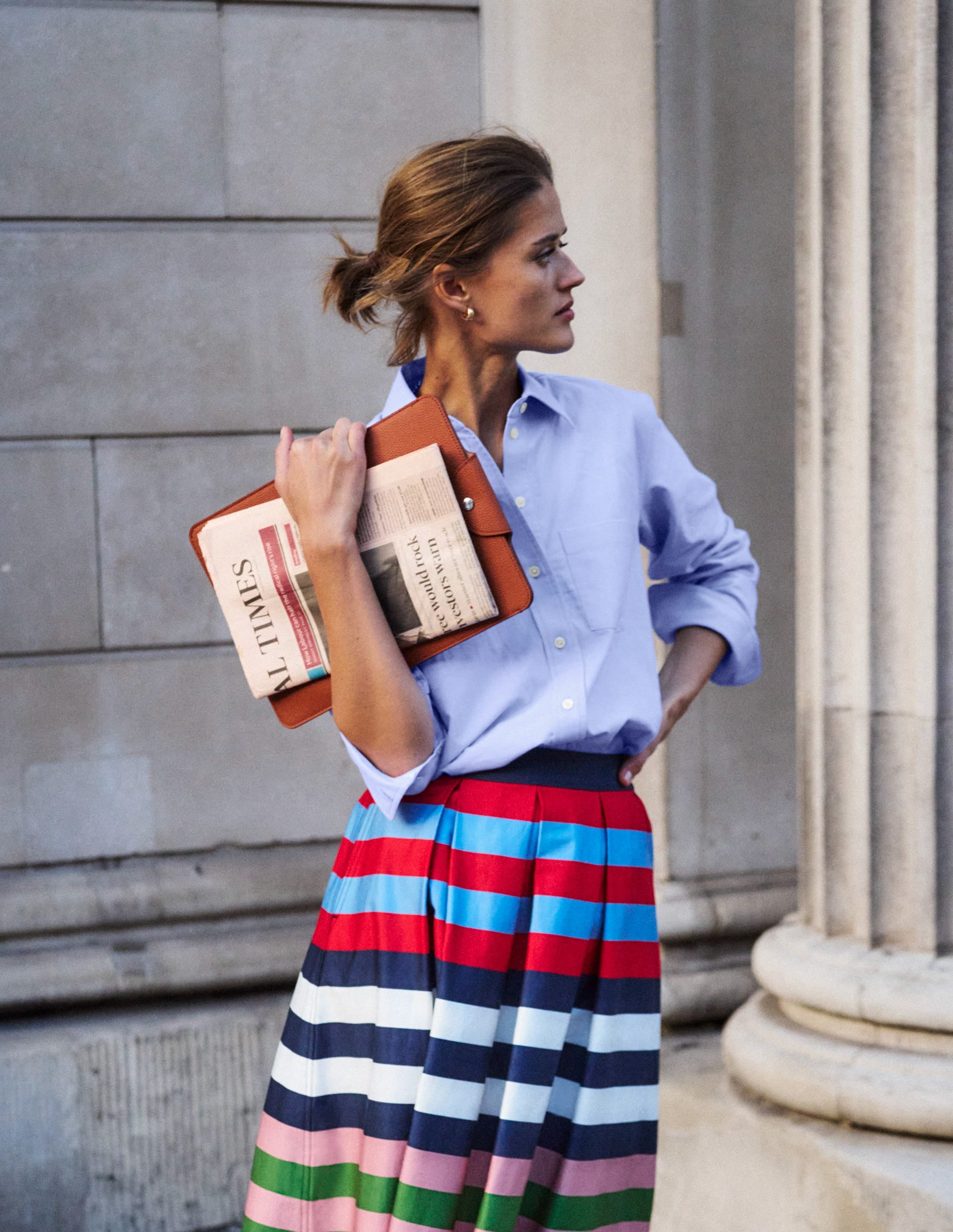 A woman wearing a light blue relaxed-fit cotton shirt with a classic collar and button-down front, styled casually.