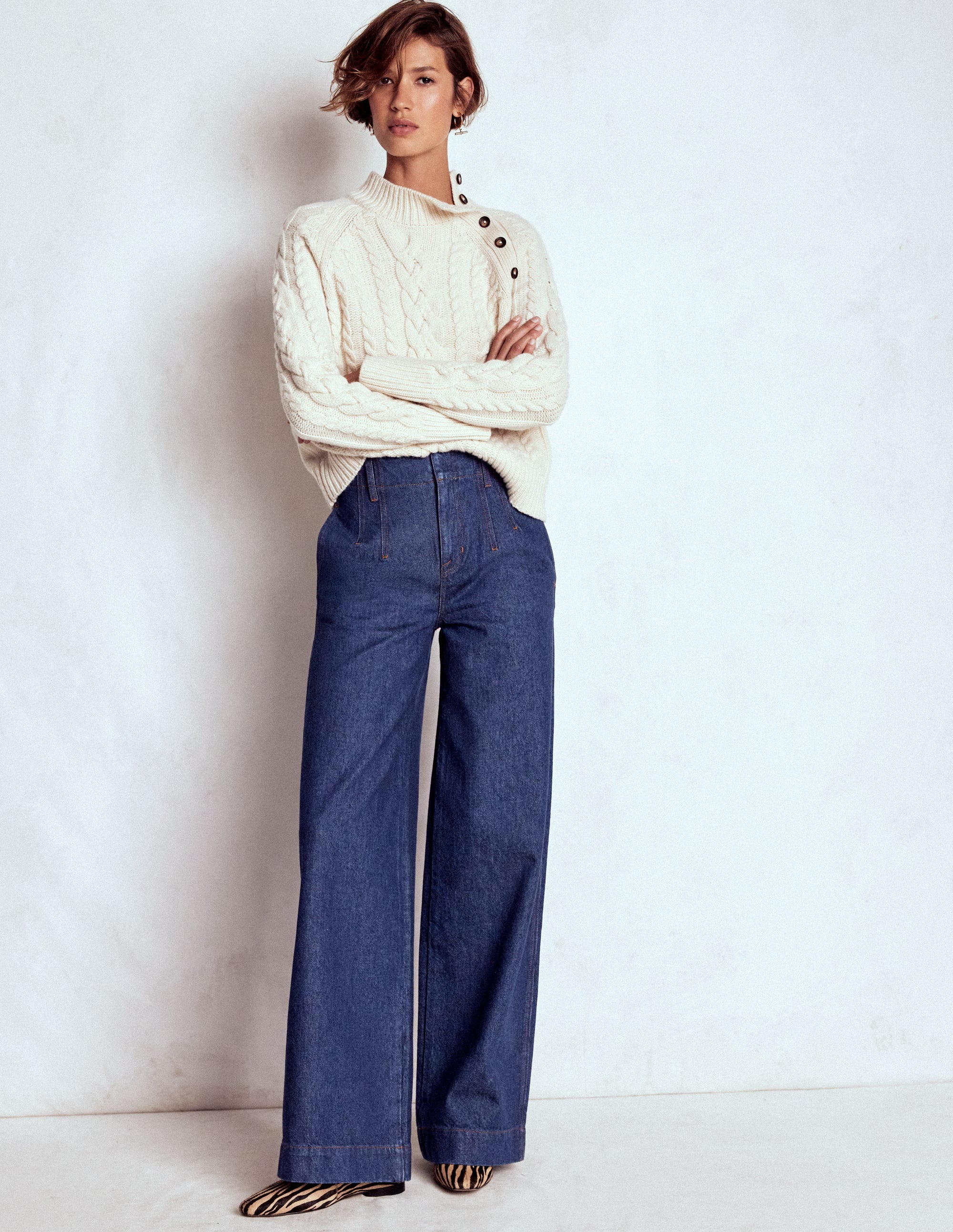 A pair of indigo wide-leg jeans with high waist and visible stitch details, shown on a model.